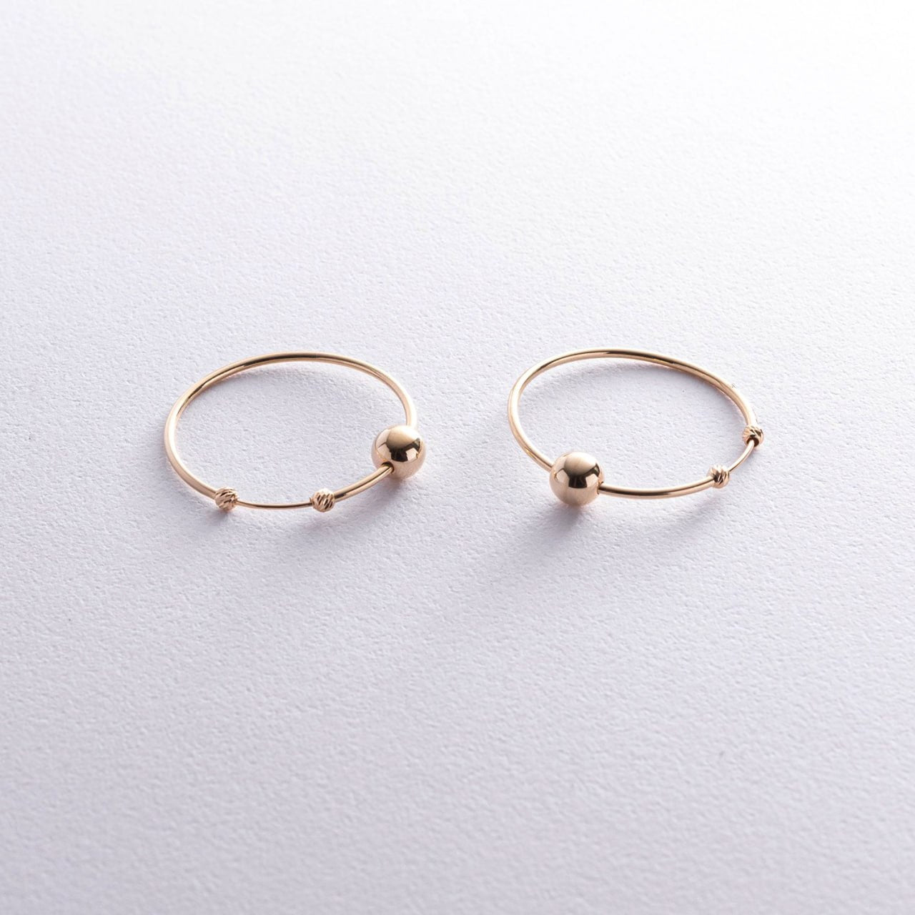Pair of gold hoop earrings with small spherical accents - lightweight and comfortable earrings