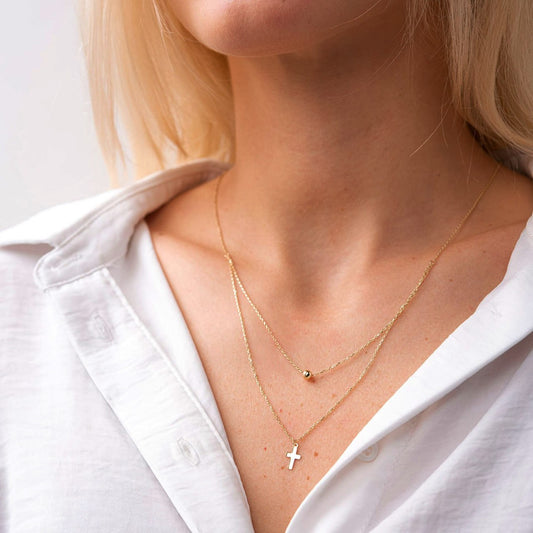 Top view of adjustable gold double chain necklace with cross and ball pendants, fine jewelry detail-religious gold jewelry-cross and ball pendant necklace