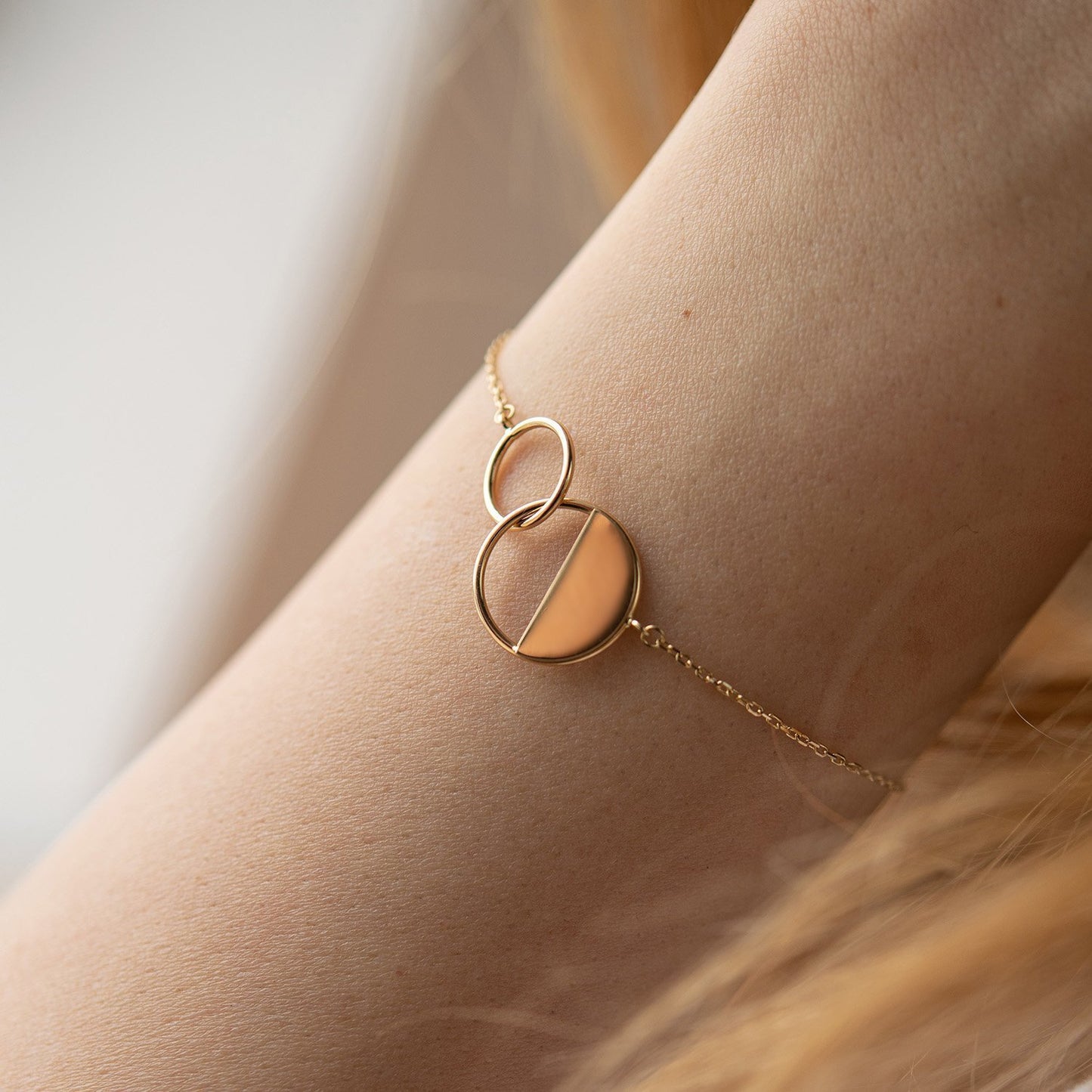 Gold bracelet with a unique design on a wrist against-Style: Minimal, modern, delicate