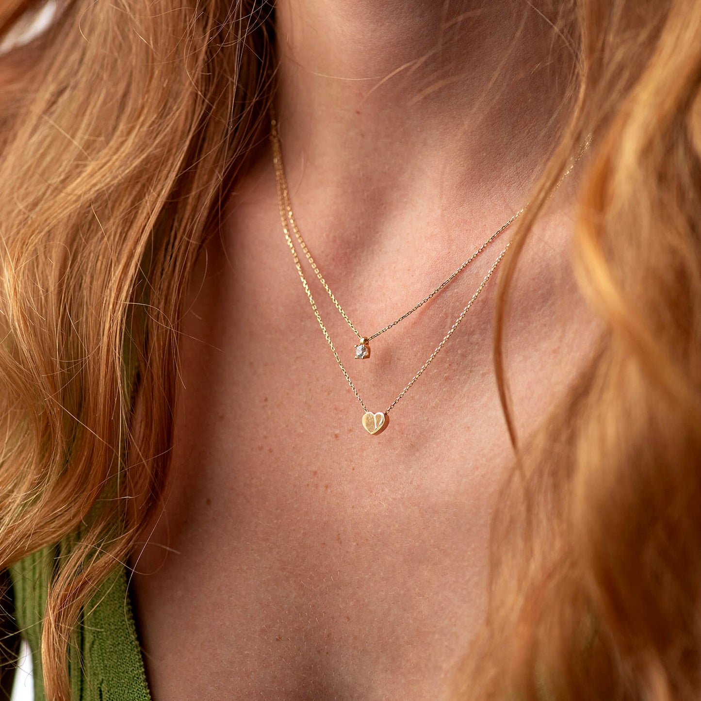 Close-up of a person wearing a gold necklace with heart pendants- timeless symbol of love and connection necklace