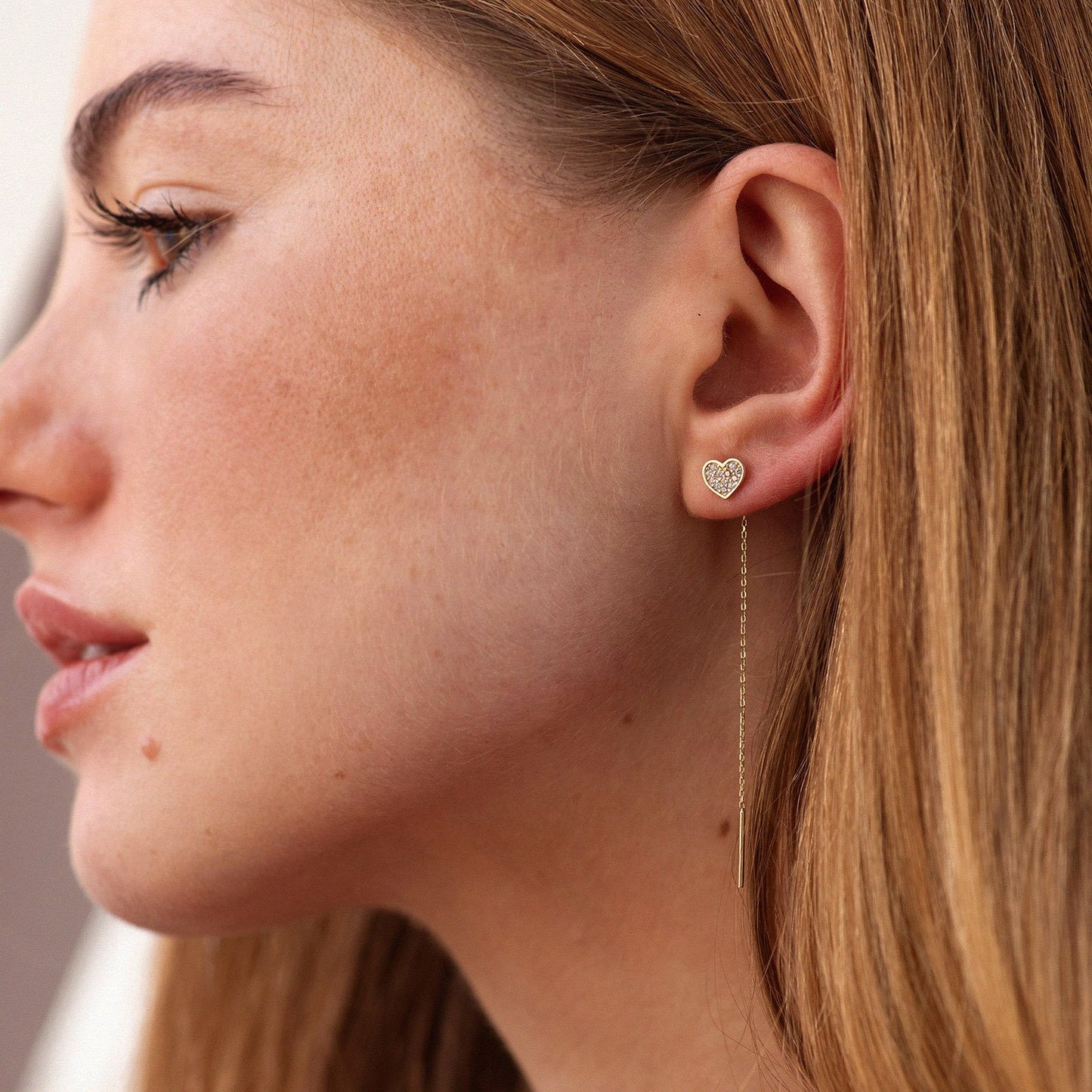 Close-up of a woman wearing a heart-shaped earring -Drop length: ~6 cm-Weight: ~0.9 g