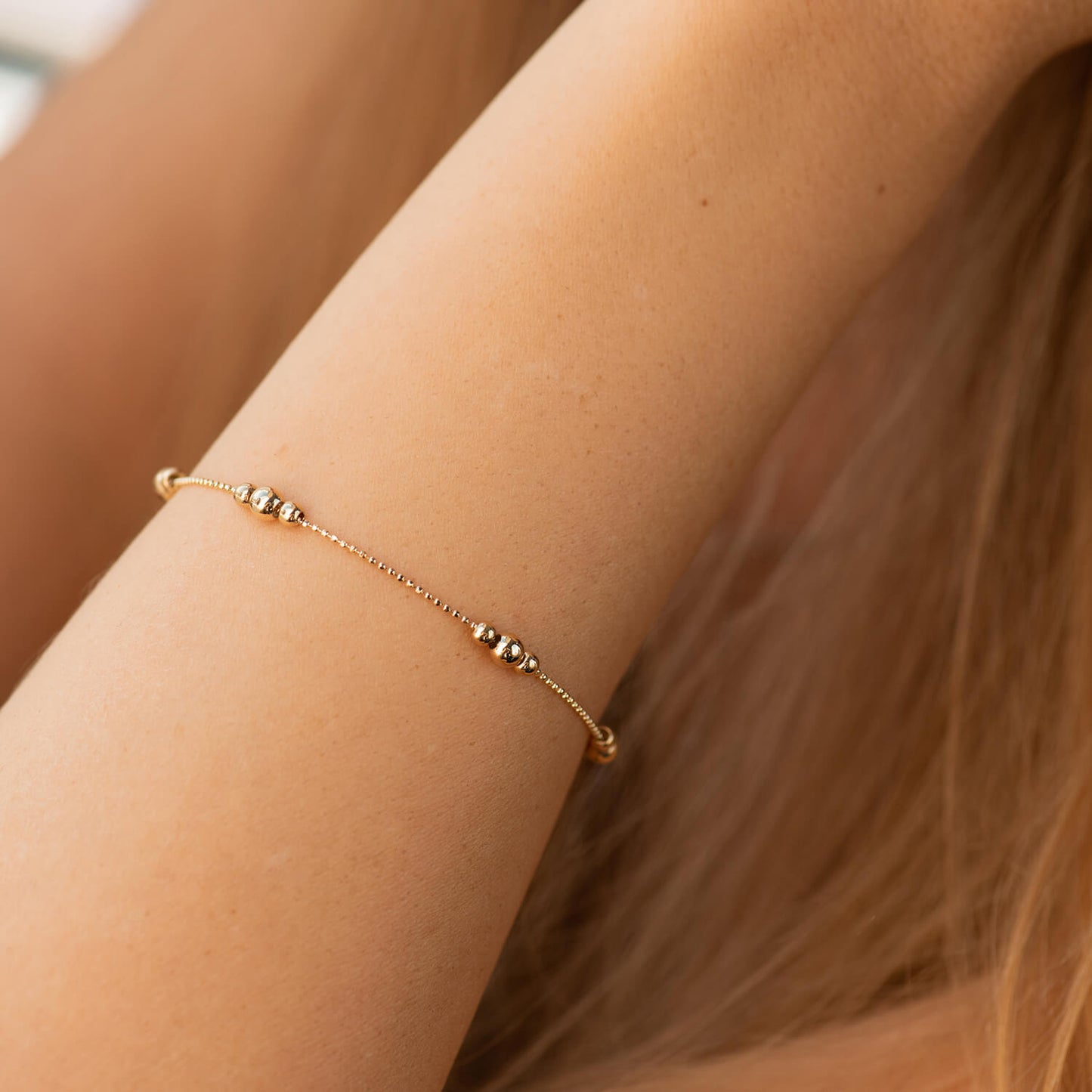 A delicate gold chain bracelet with small metallic bead accents, shown worn on a person's wrist - size 17-20 cm - weight 2-2.2 g -ready to ship