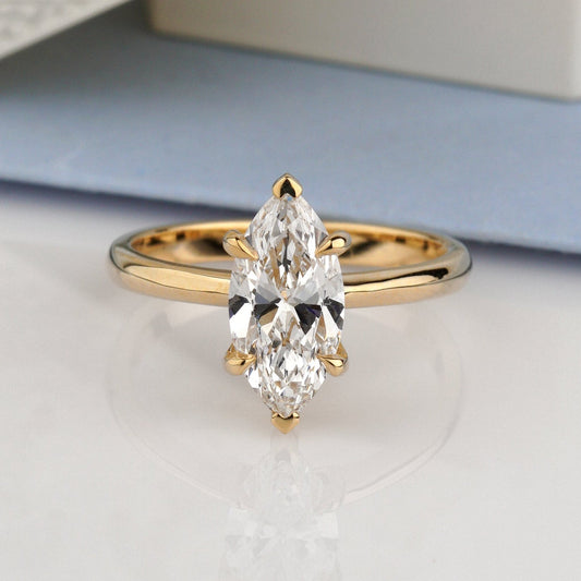 A gold ring with a marquise-cut clear gemstone-marquise diamond ring
lab grown diamond ring
14k gold engagement ring