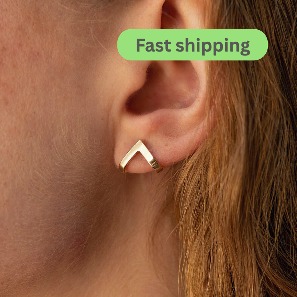 Gold V-shaped earring worn on ear