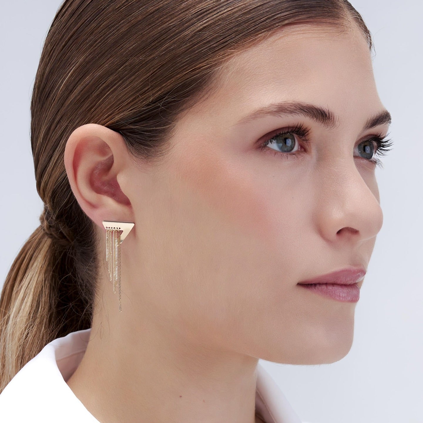 Woman wearing Statement Gold Earrings-bold, geometric triangle stud