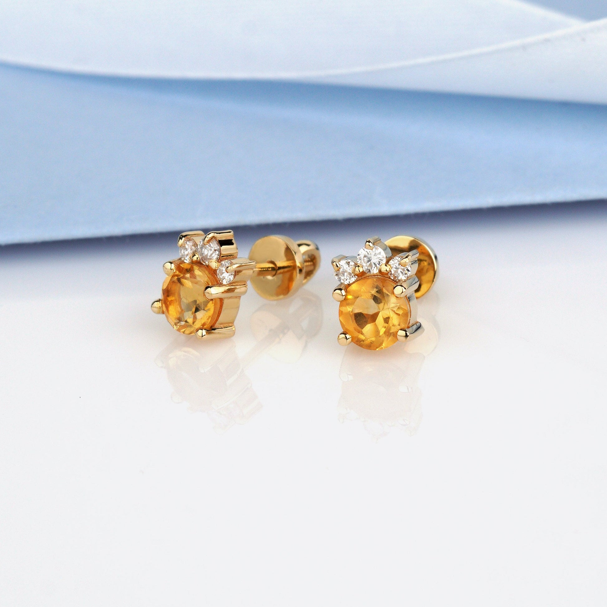 A pair of gold stud earrings with round yellow gemstones and small clear accent stones-14k solid gold, 585 fineness-Stones: Citrine + Moissanites (0.15 ct)