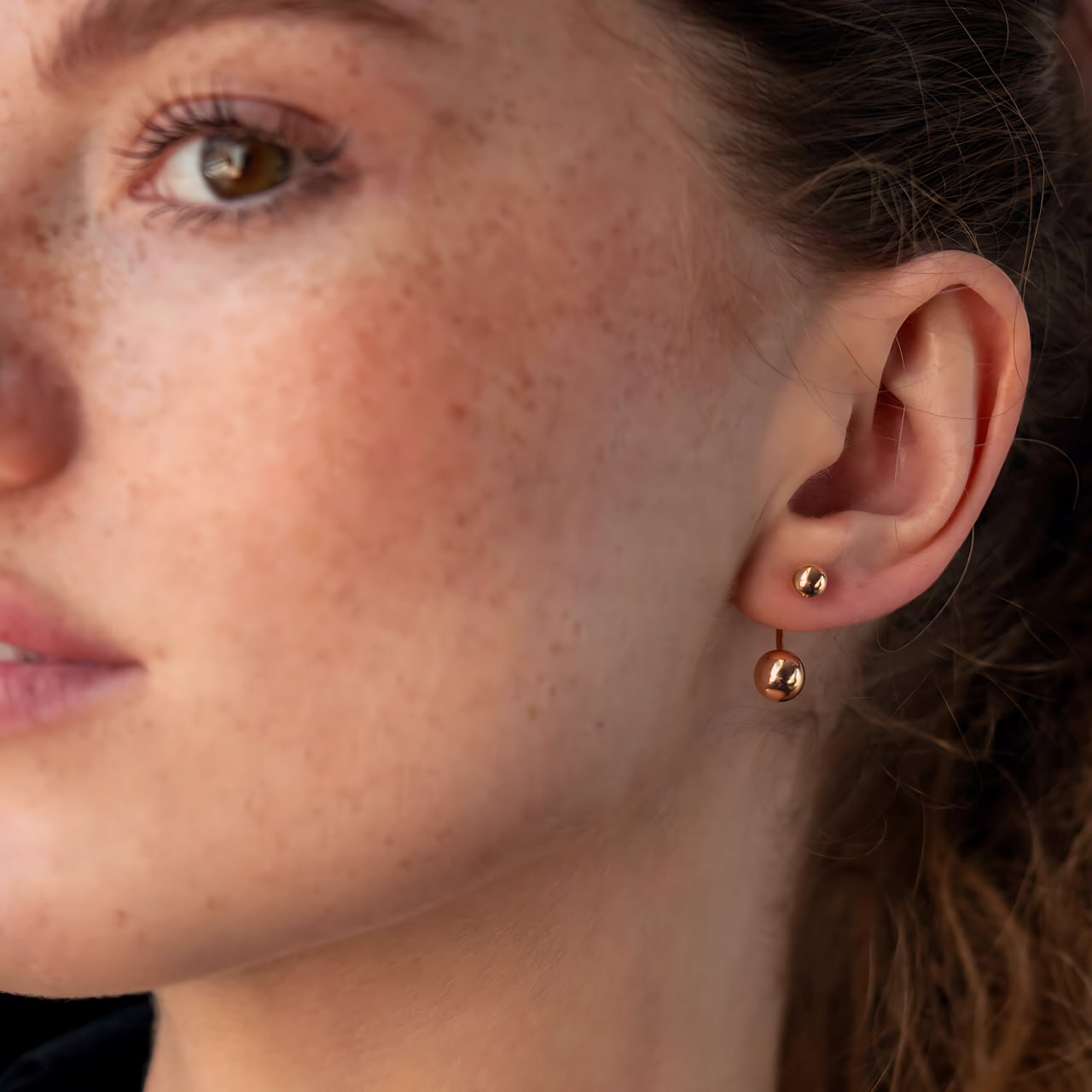 Close-up of a woman's ear wearing gold ball earrings-Lightweight and comfortable for everyday wear