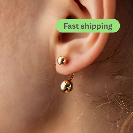 Gold earring worn on an ear 