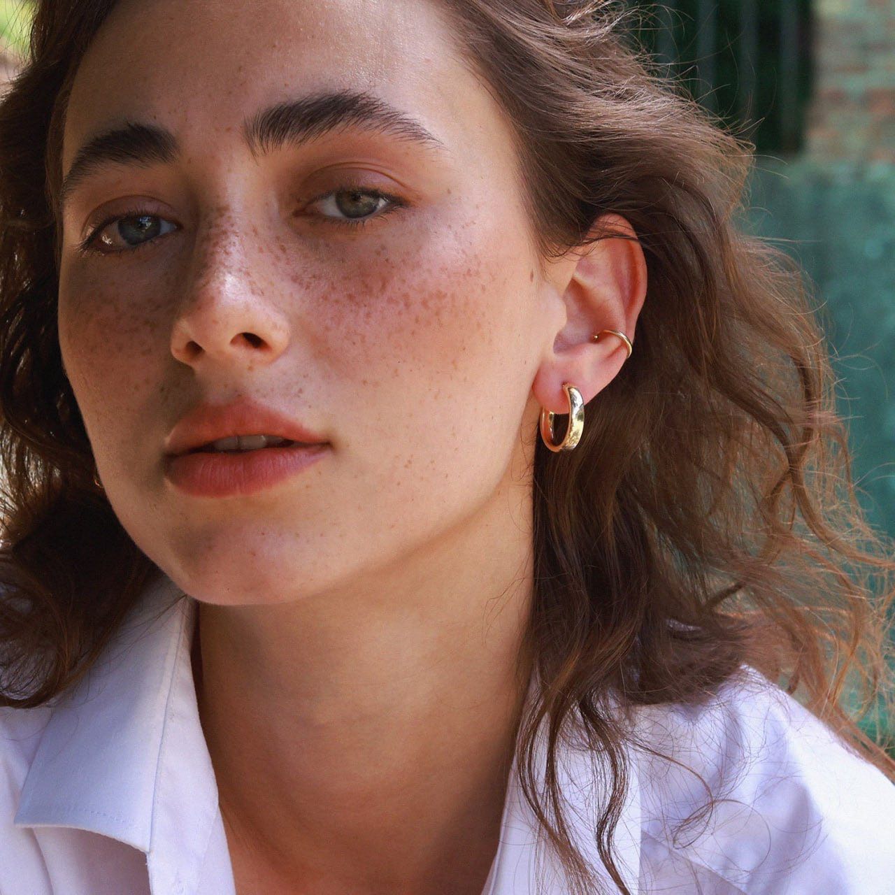 Side view of solid gold hoop earrings showing width and polished finish on girl on the ears-minimalist hoops