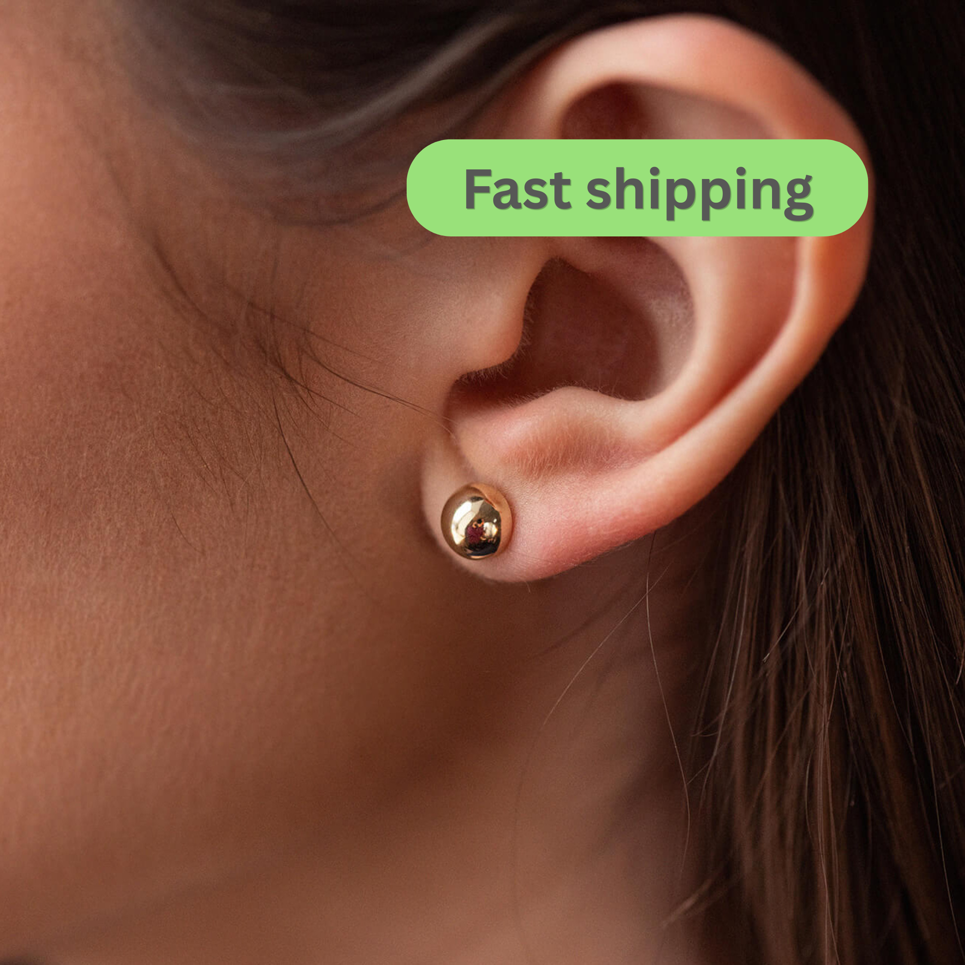 Gold earring worn on an ear 
