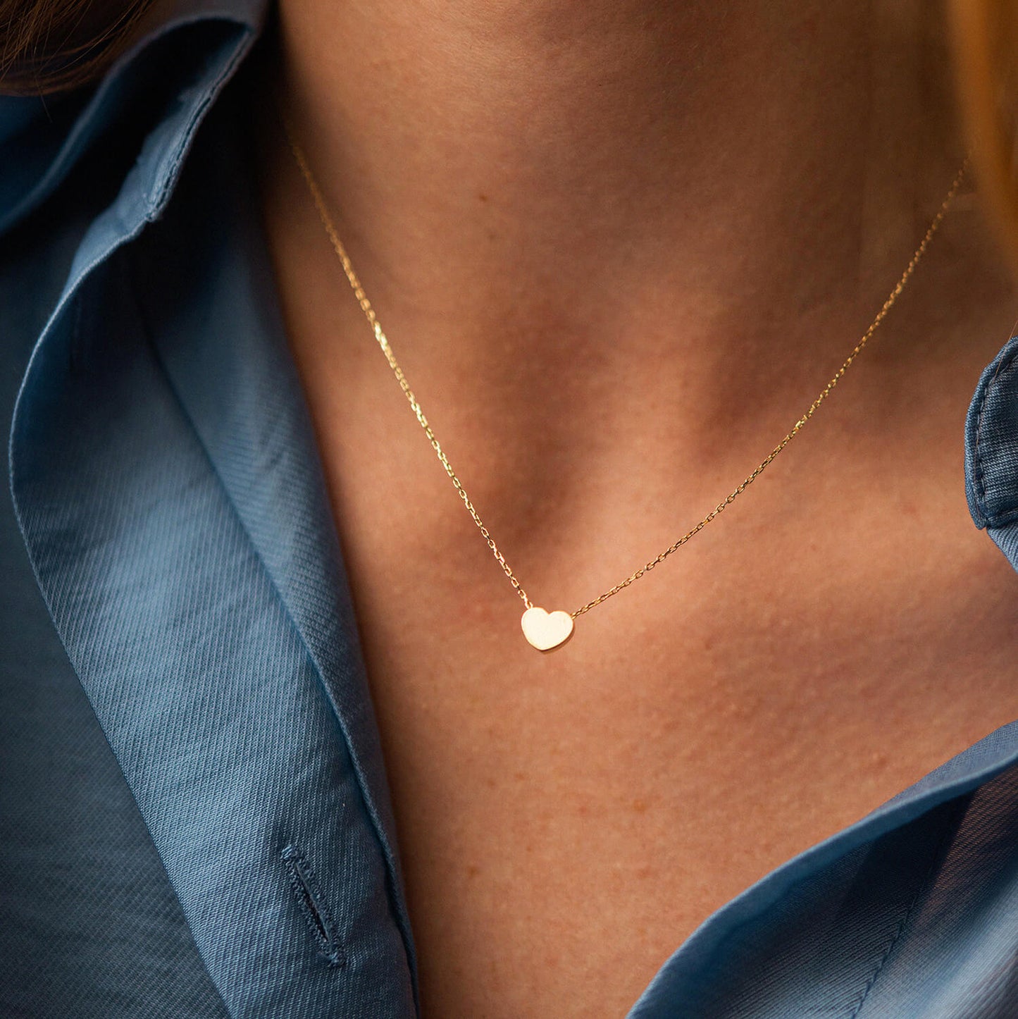 Gold necklace with a heart pendant worn by a person -Weight: Approx. 1.6 g