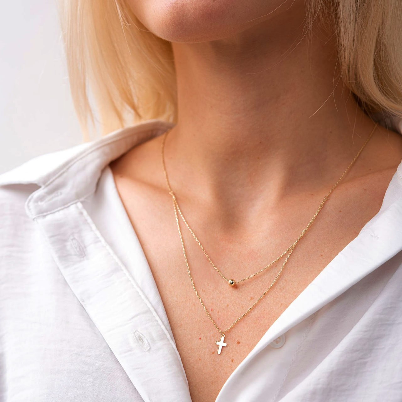 Top view of adjustable gold double chain necklace with cross and ball pendants, fine jewelry detail-religious gold jewelry-cross and ball pendant necklace