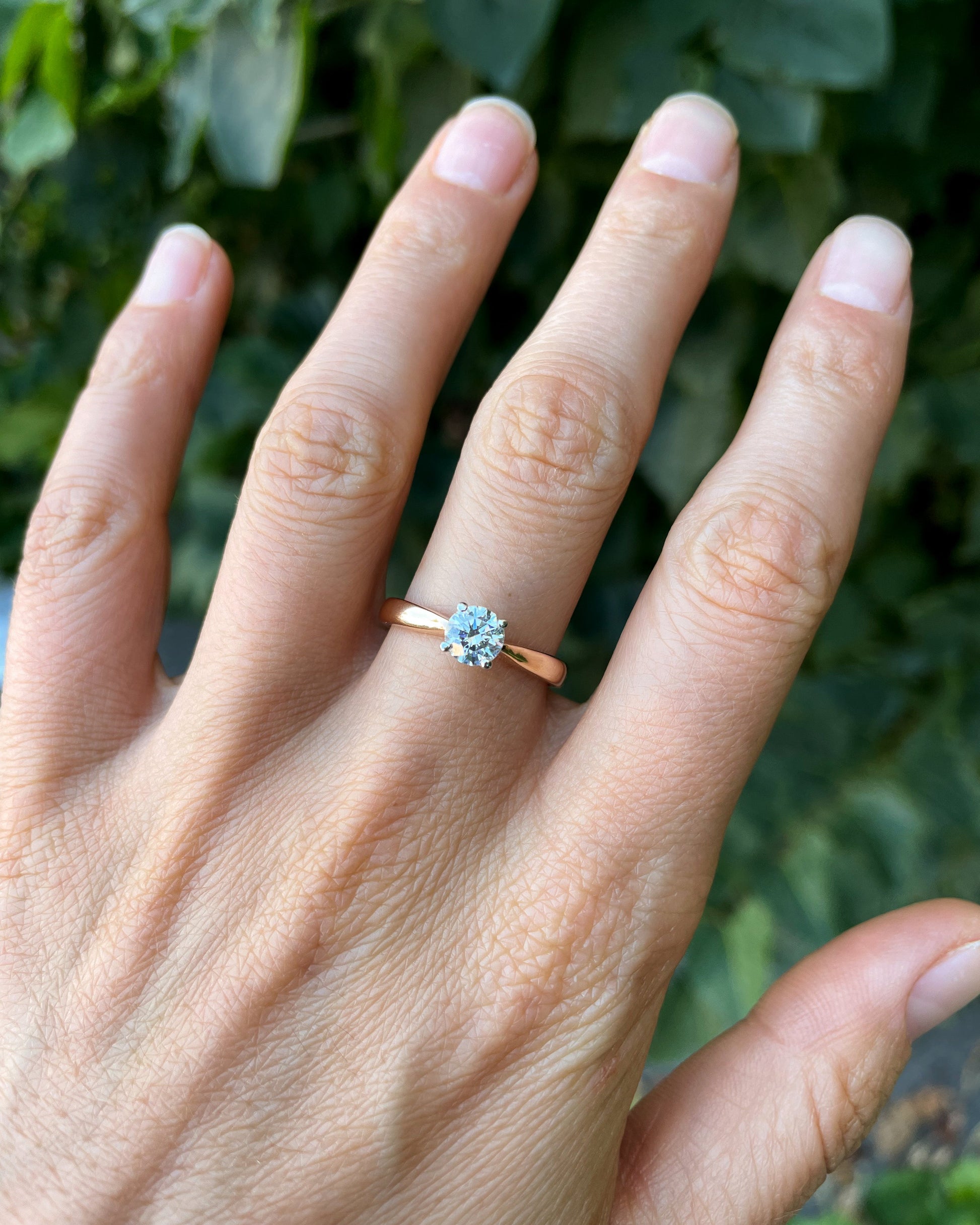 Hand wearing a rose gold ring with a diamond -IGI certified lab-grown diamond  0.5 ct, VVS2 / D color
