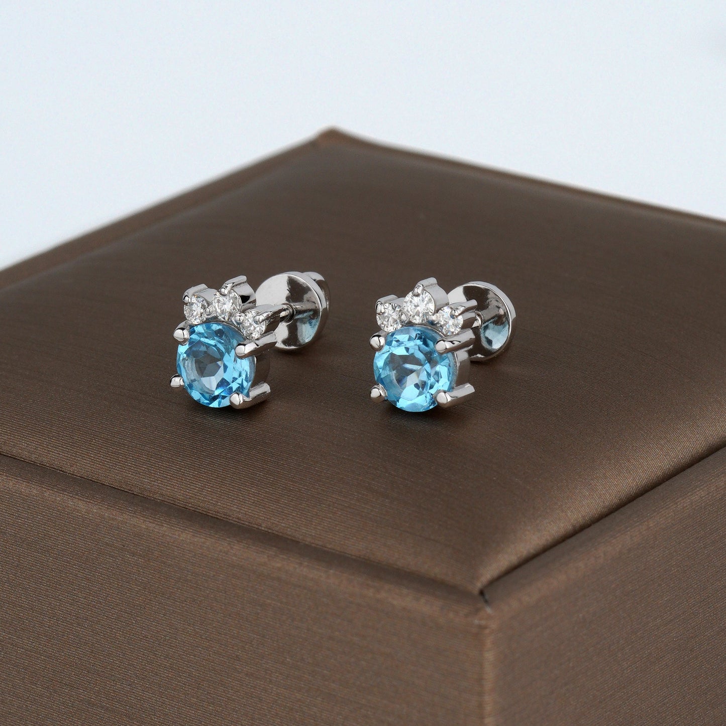 A pair of silver stud earrings with oval light blue gemstones and small clear accent stones-Weight: 2.3–2.5 g-Size: 8mm