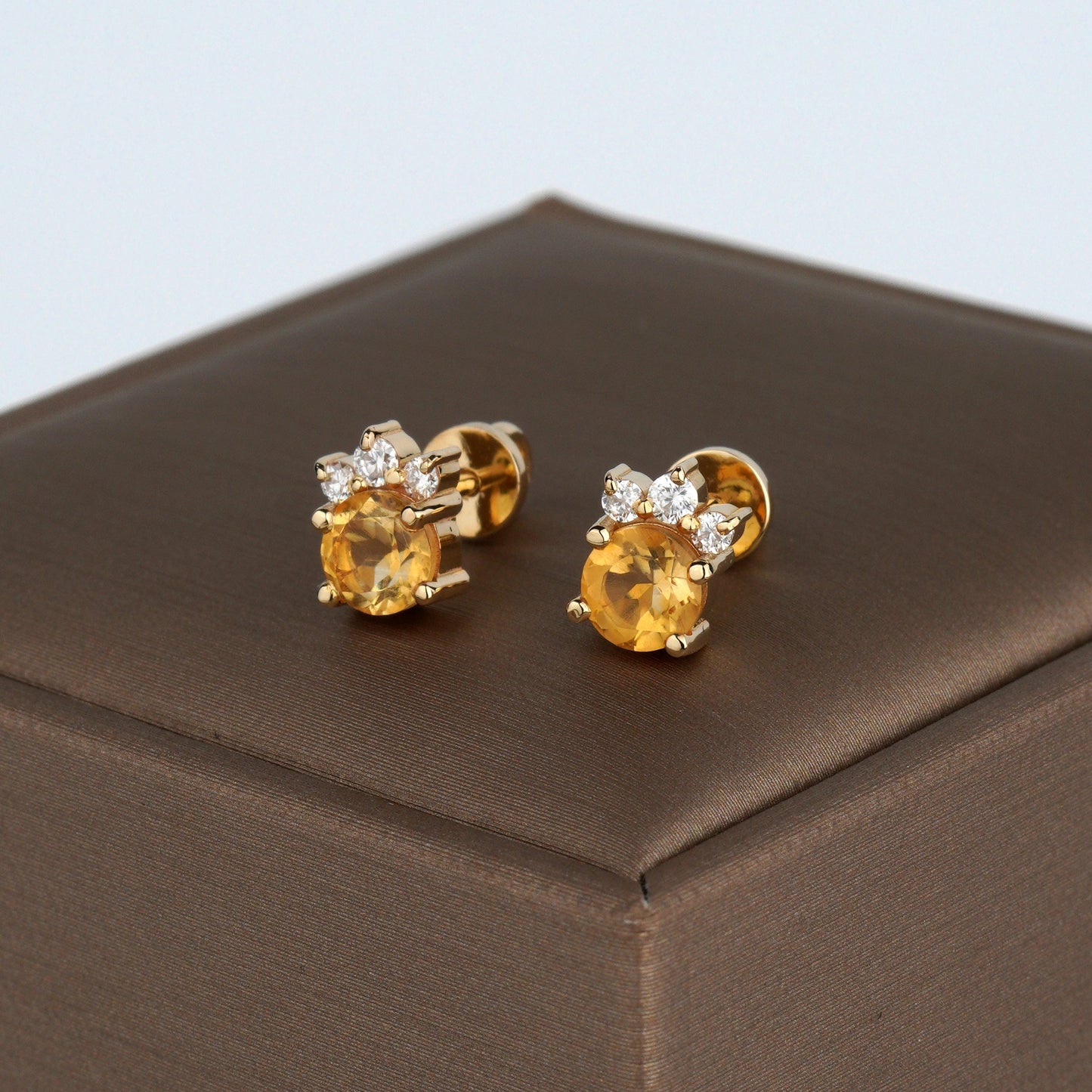 A pair of gold stud earrings with round yellow gemstones and small clear accent stones-Closure: stud (screw-back)-Weight: 2.3–2.5 g-Size: 8mm