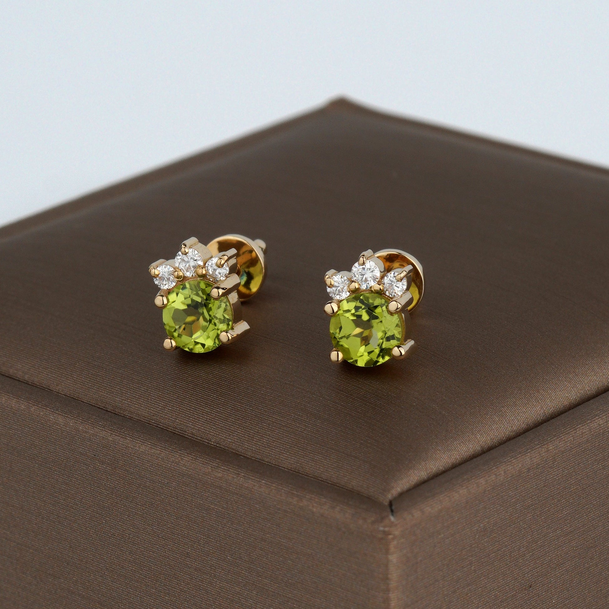 A pair of gold stud earrings with oval green gemstones and small clear accent stones-Weight: 2.3–2.5 g
Size: 8mm