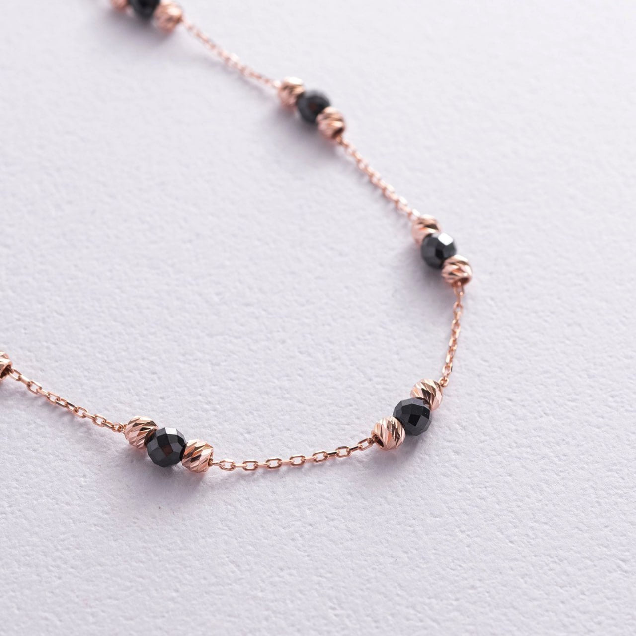 A delicate rose gold chain necklace featuring small faceted black beads wrapped in twisted rose gold wire-black and rose gold bracelet-faceted bead rose gold bracelet-adjustable rose gold bracelet