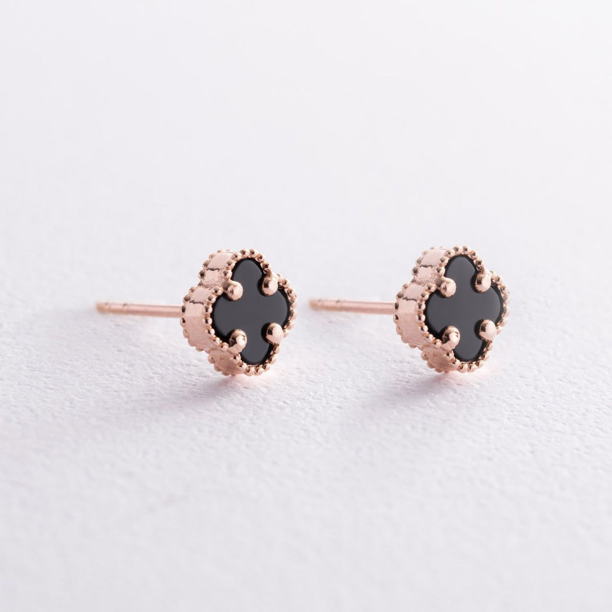 A pair of rose gold stud earrings with black clover-shaped inlays, shown on a clean white textured background-solid gold earrings
everyday earrings
gift for her