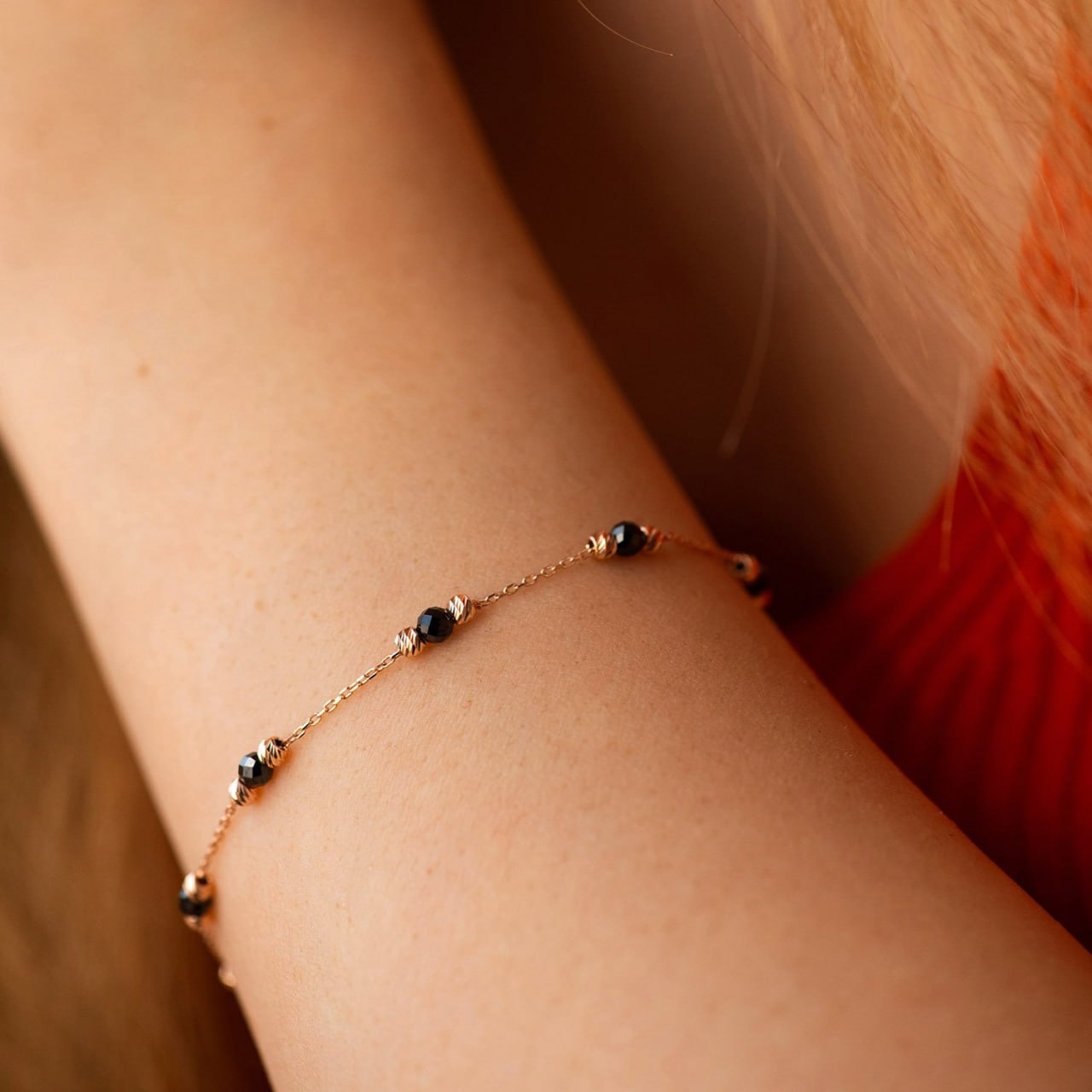A delicate gold chain bracelet with small dark beads and tiny clear stones, worn on a person's wrist-everyday rose gold bracelet-black stone gold bracelet gift-unique rose gold bracelet women