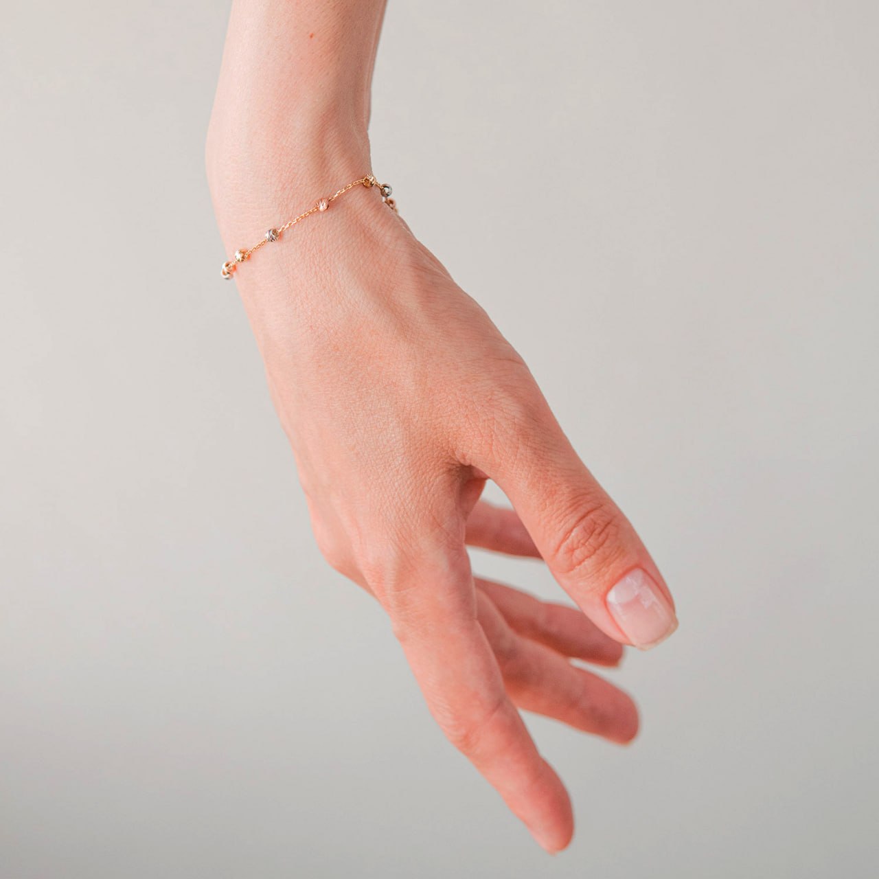 A delicate rose gold chain bracelet with small bead accents worn on a person's wrist-adjustable gold bracelet women-minimalist gold bead bracelet-stackable gold bracelet