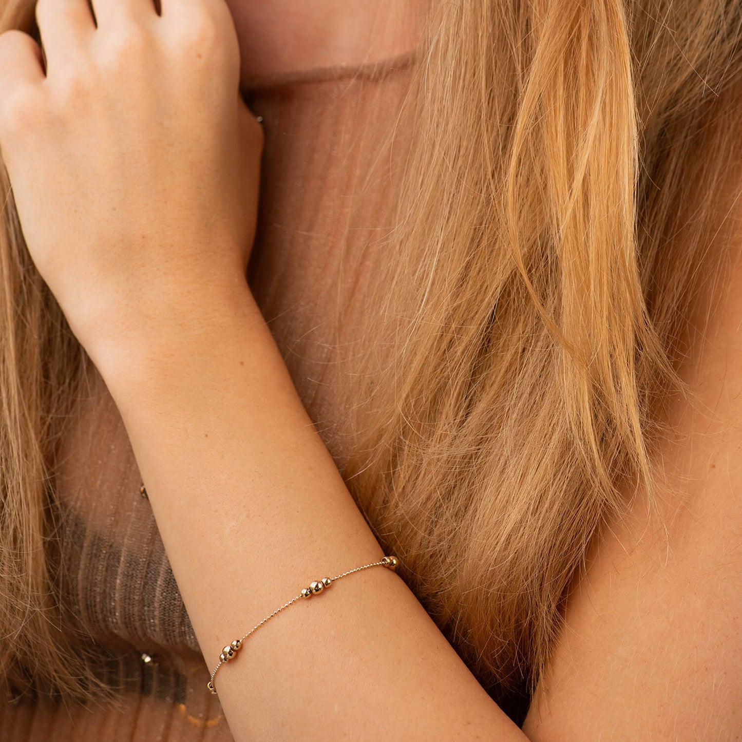 A delicate gold chain bracelet with small bead details worn on a woman's wrist-everyday gold bracelet-gold ball chain bracelet-stackable gold bracelet