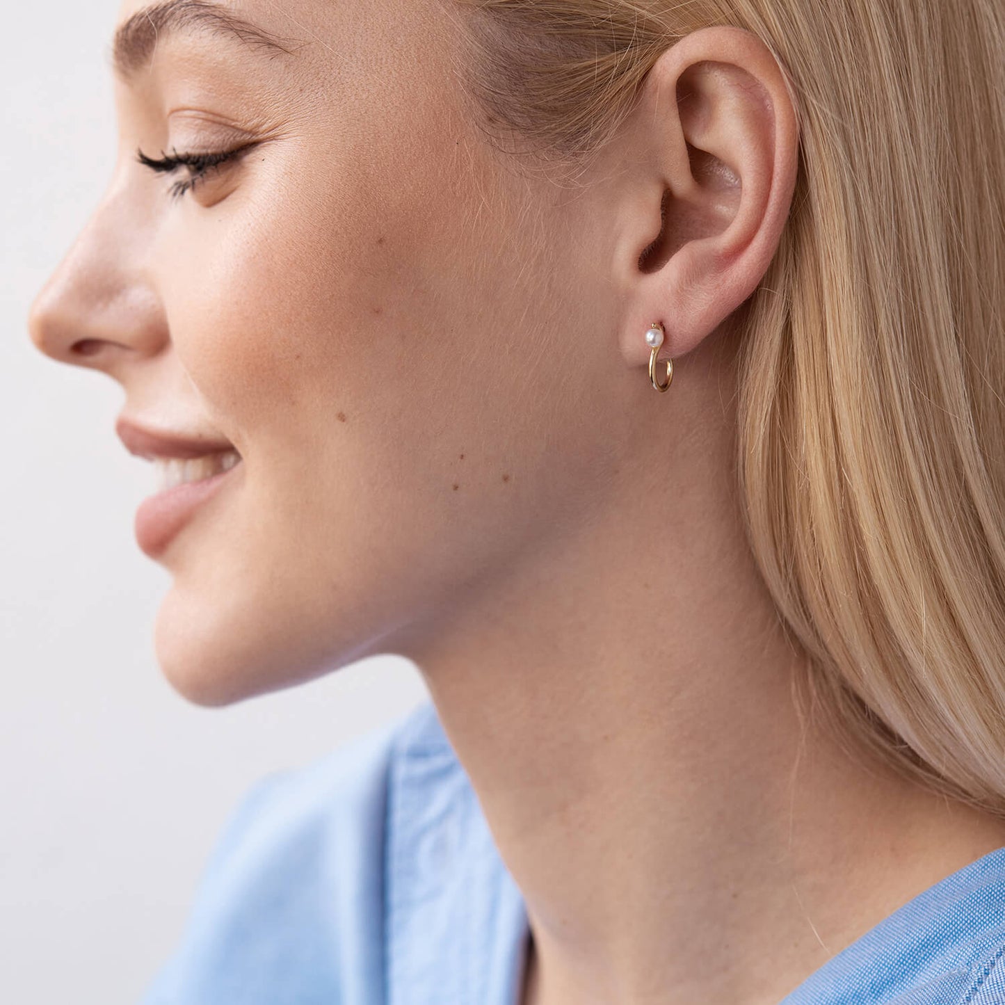 Close-up of a woman wearing gold hoop earrings -comfortable gold stud earrings