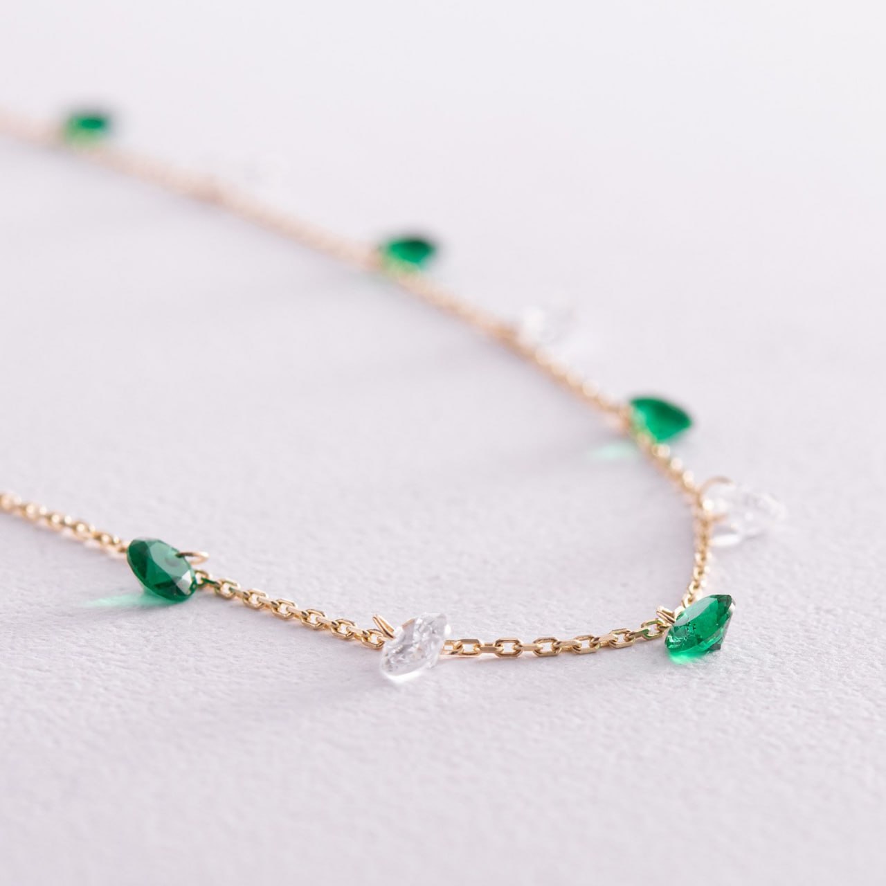 A delicate gold chain necklace featuring small green faceted gemstone beads and clear crystal beads-scatter necklace-delicate chain necklace