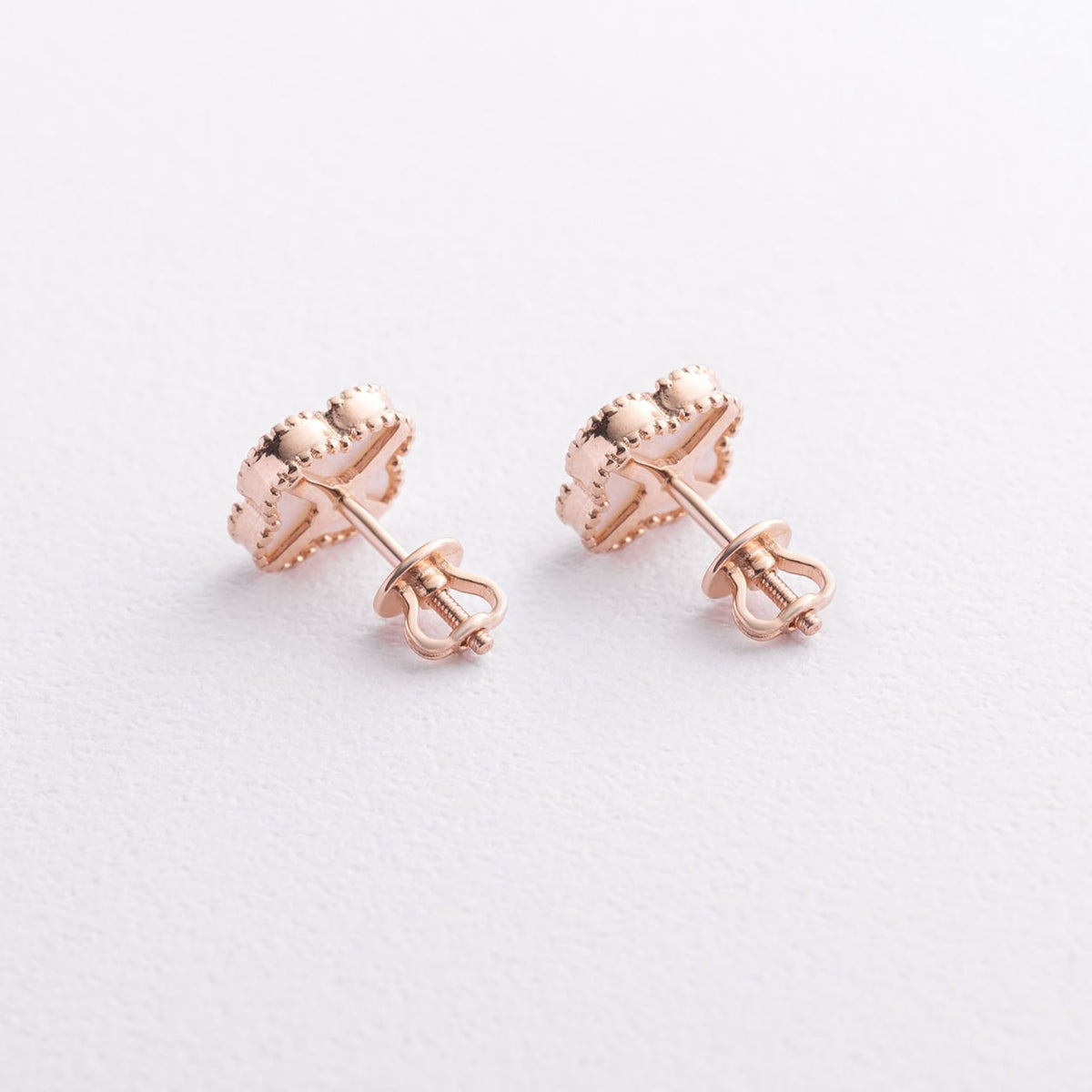 A pair of rose gold stud earrings with a textured, scalloped floral or leaf-like design, shown from the back on a clean white background-small gold studs
delicate gold earrings