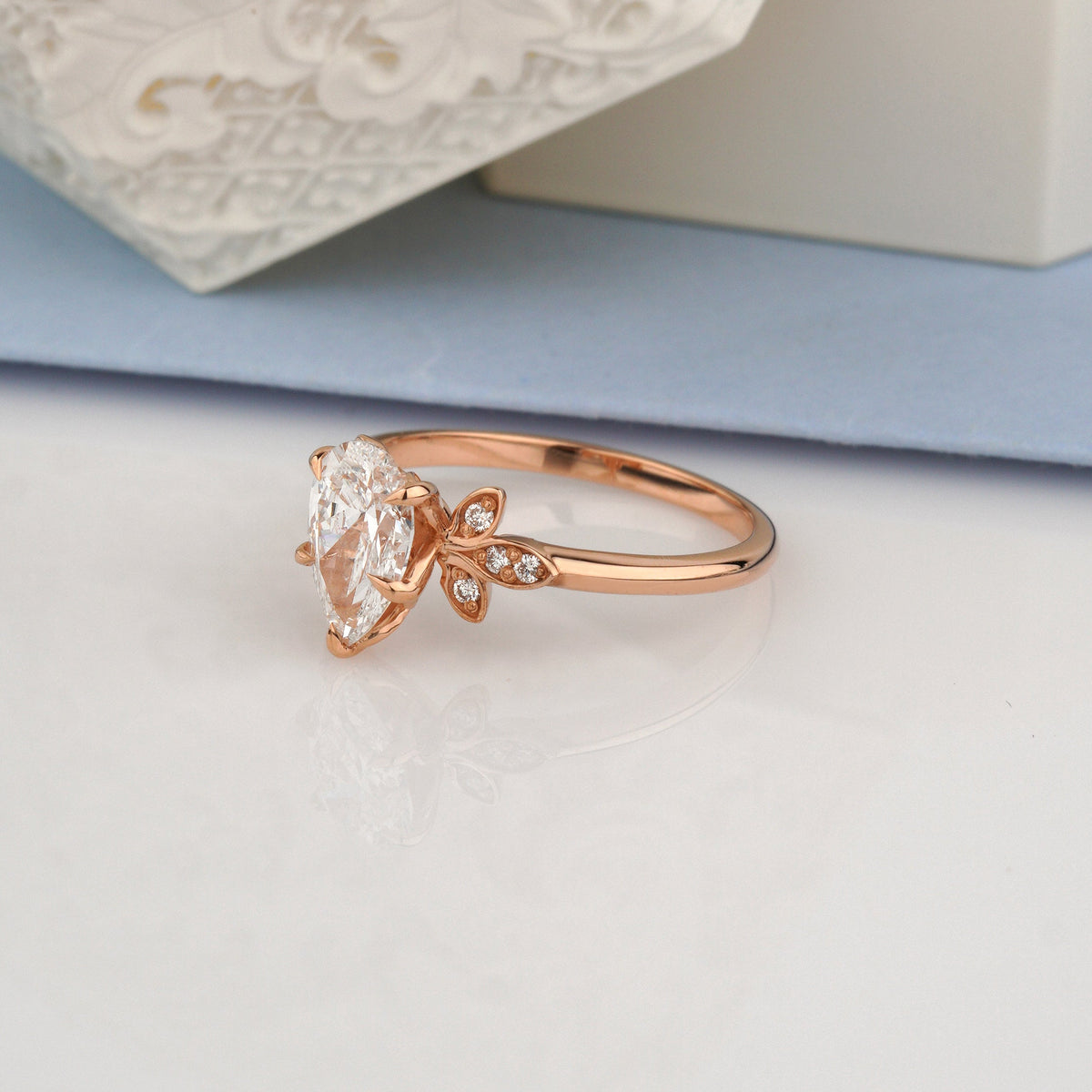 A rose gold ring with a large clear marquise-cut center stone and small side stones-lab grown diamond ring
vintage floral ring-1 ct pear diamond ring
pear cut engagement ring