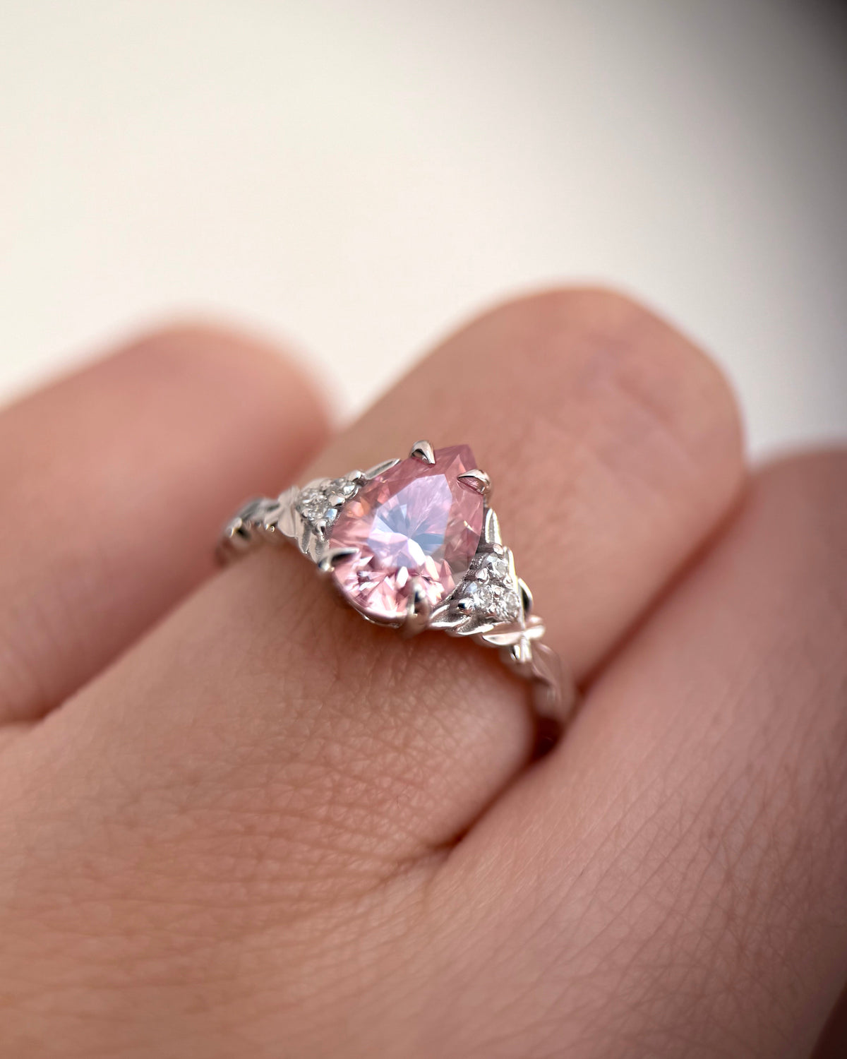 A silver ring with a heart-shaped pink gemstone and small side stones, shown worn on a finger-pink gemstone ring-alternative engagement ring-promise ring for her