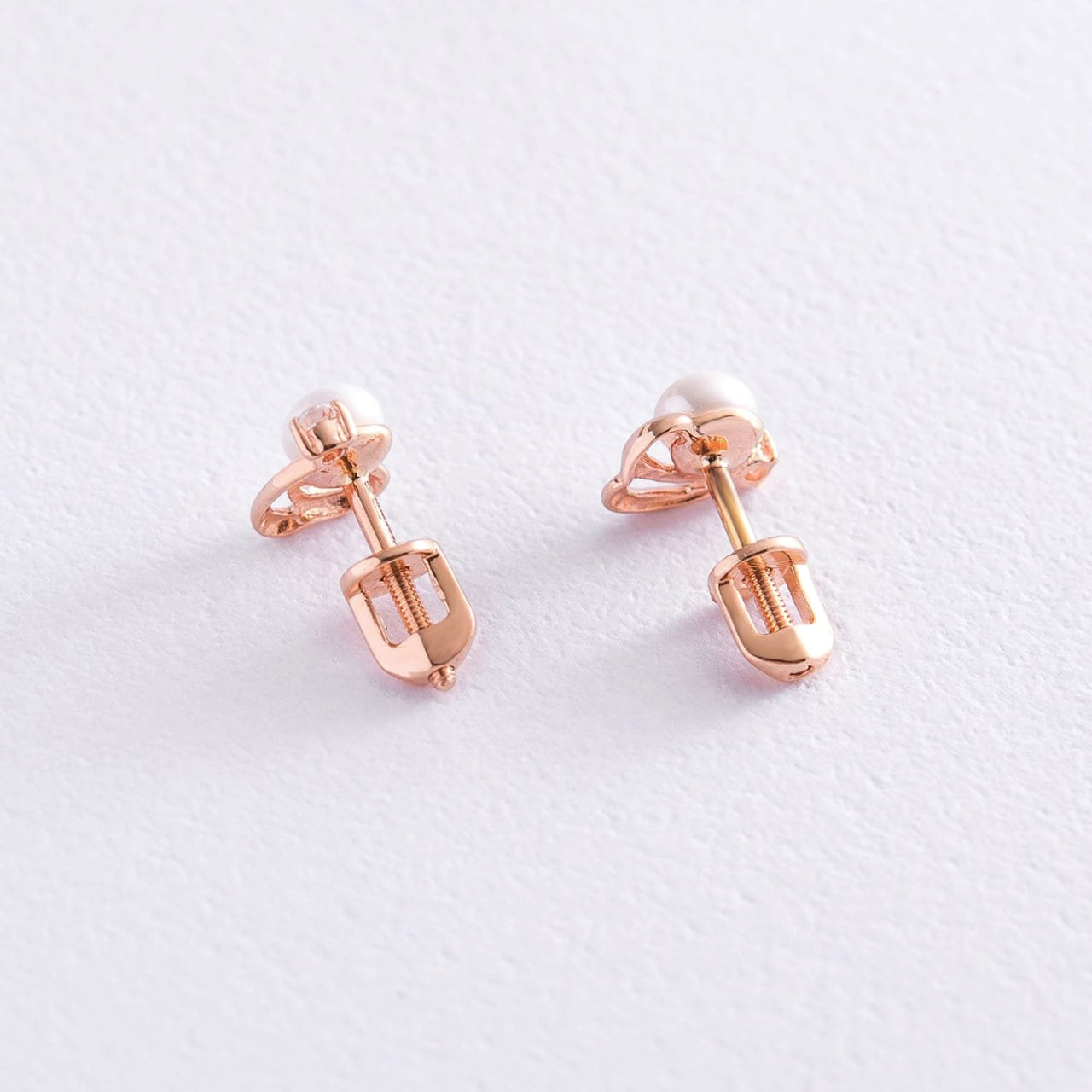 A pair of rose gold stud earrings with a small white pearl-delicate pearl earrings
dainty pearl earrings-minimalist gold earrings