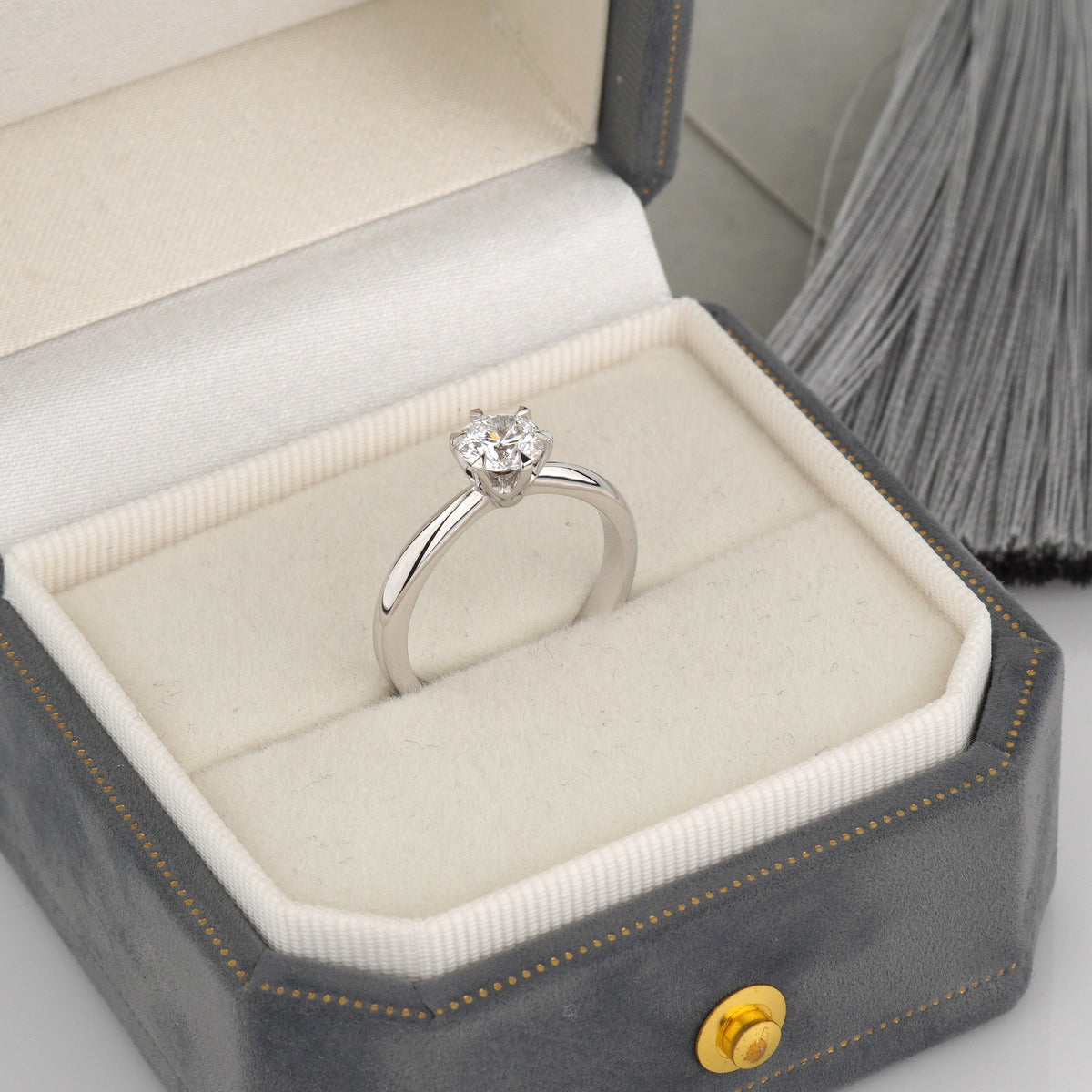 A white gold solitaire ring with a round clear gemstone is displayed inside an open gray velvet jewelry box with a cream cushion-Metal: 14k White Gold (585), solid
Center Stone: Lab-Grown Diamond, Round Cut, 0.7 ct VVS2/D, IGI Certified