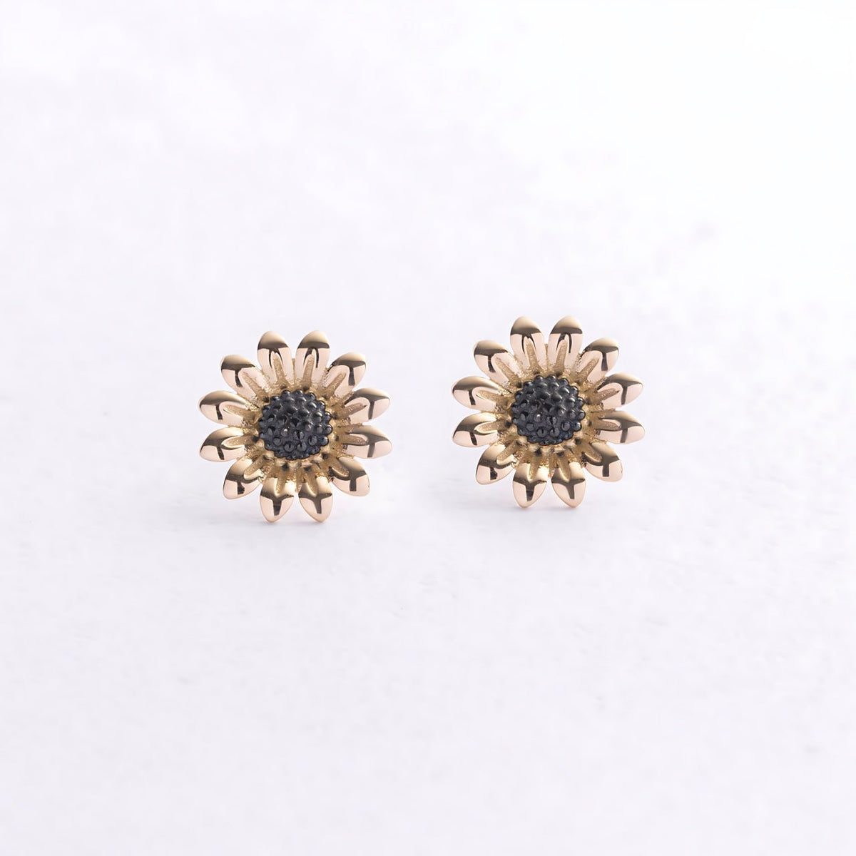 A pair of gold-toned daisy stud earrings with dark gray textured centers-flower stud earrings-flower gold earrings-minimalist gold earrings