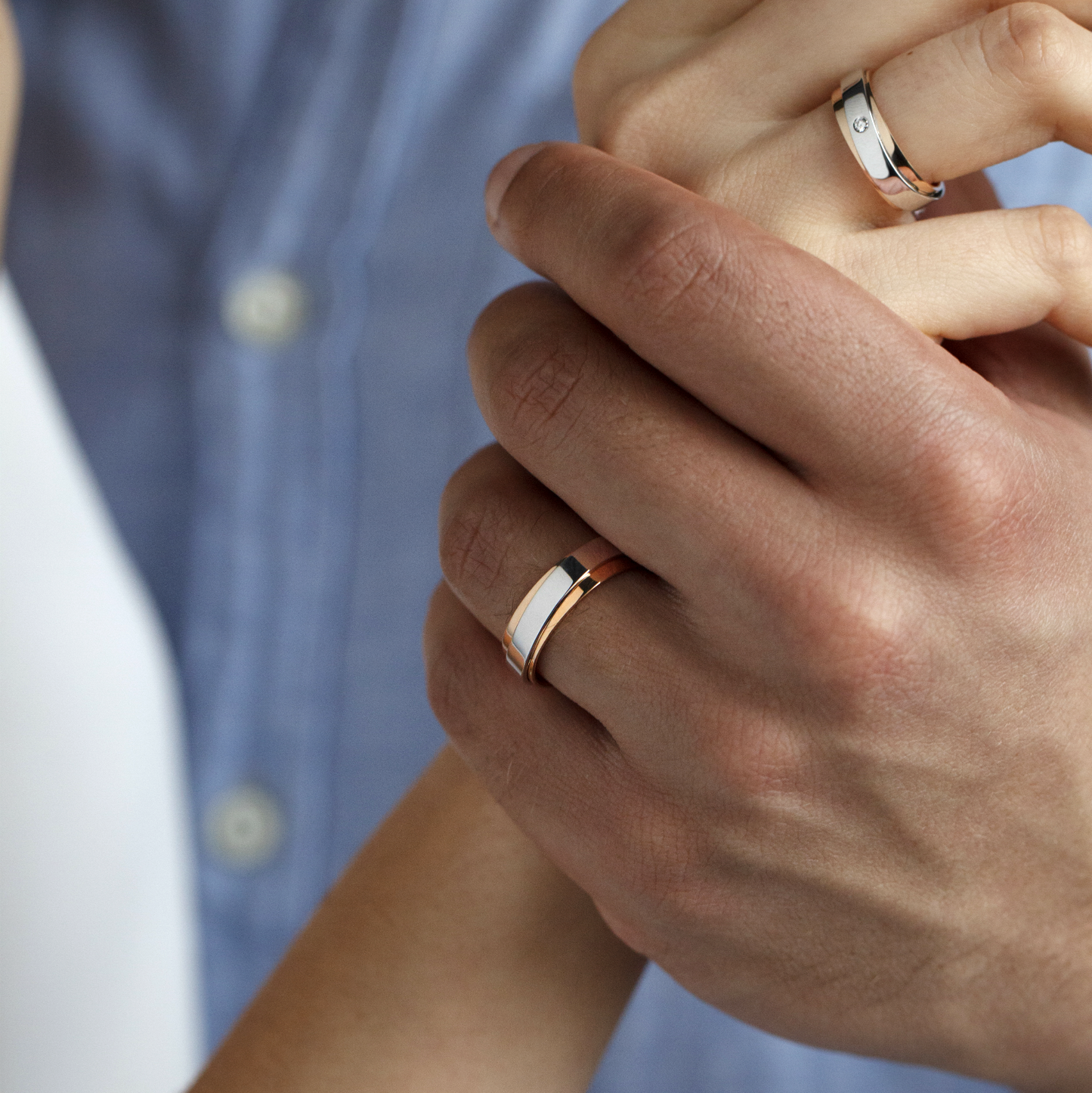 Close-up of two hands wearing slim metallic rings-6mm wide-available in 18k gold and platinum on request