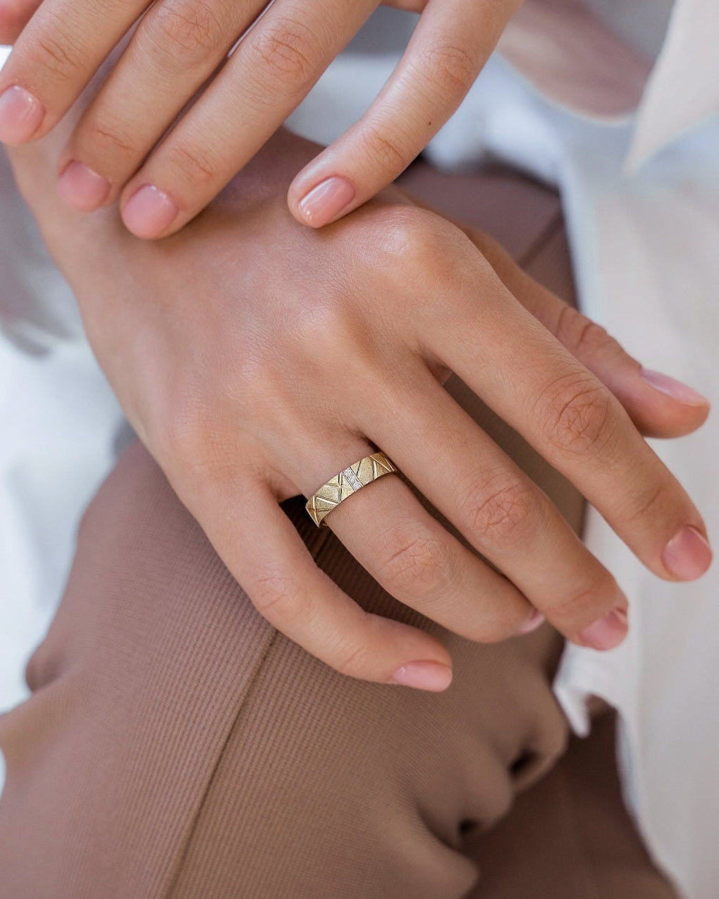 Close-up of a hand wearing a gold ring -made of solid 14k gold and natural diamonds.